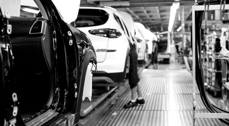 Car frames moving through an automotive manufacturing facility
