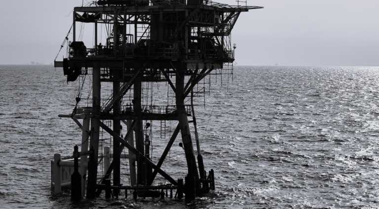 Oil rig surrounded by ocean in black and white