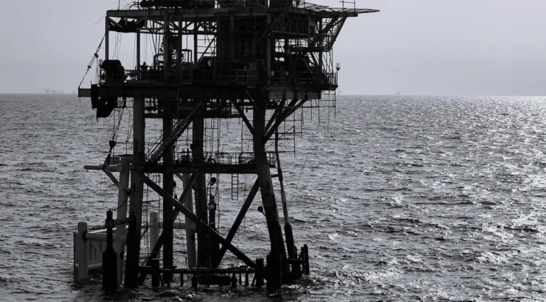 Oil rig surrounded by ocean in black and white