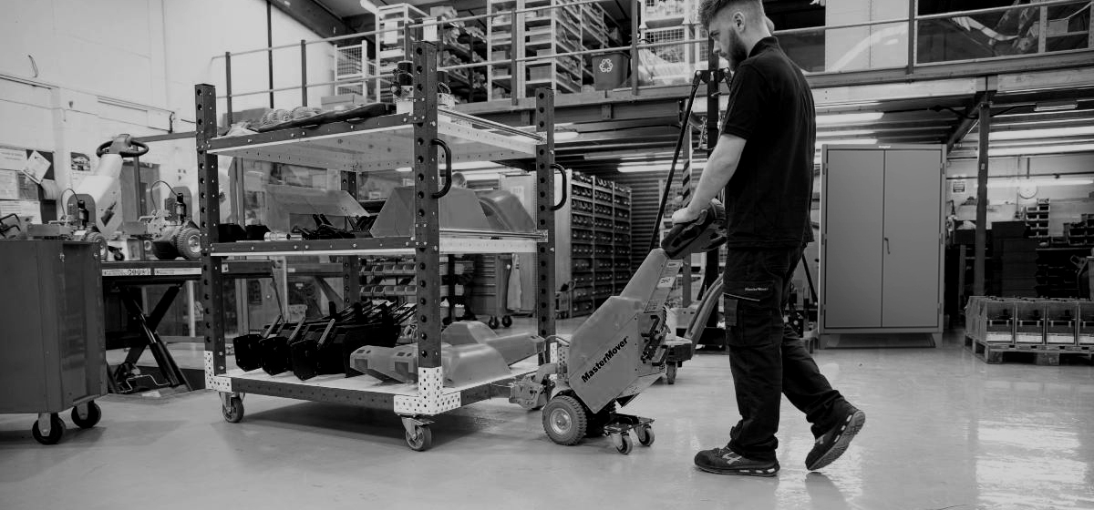 Distribution center worker with a pallet jack in front of a Strong Hold cabinet