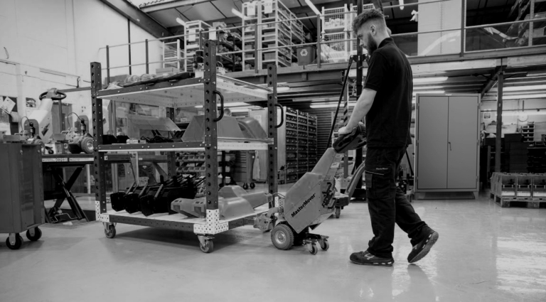 Distribution center worker with a pallet jack in front of a Strong Hold cabinet