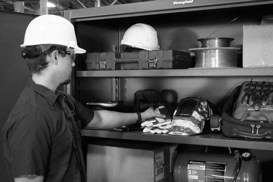 Man in hardhat selects gear from a Strong Hold cabinet
